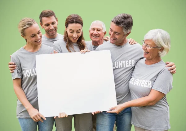 Freiwillige mit großer Blankokarte vor grünem Hintergrund — Stockfoto