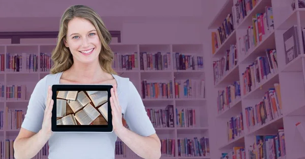 Kadın pembe kaplaması ile bulanık bookshelf karşı açık kitapları gösterilen tablet ile — Stok fotoğraf