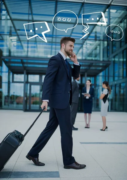 Деловой человек с чемоданом по телефону с белыми речевыми пузырями — стоковое фото
