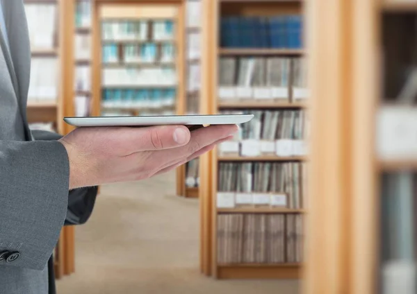 Mans händer som håller tablett i biblioteket — Stockfoto