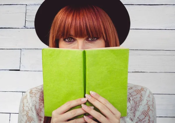 Vrouw leest tegen witte houten paneel — Stockfoto