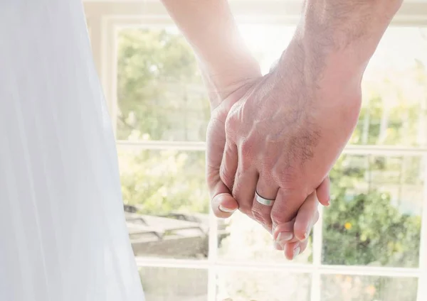 Hochzeitscoupe hält Händchen am Fenster — Stockfoto