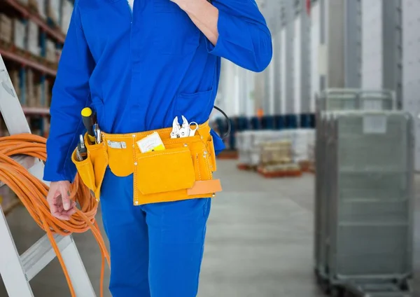 Handwerker mit Leiter gegen verschwommenes Lager — Stockfoto