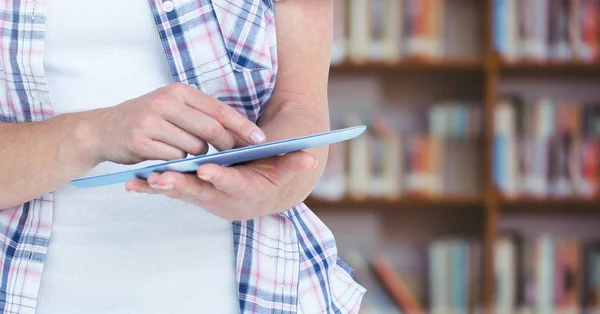 Womans hands touching tablet in Library — Stock Photo, Image