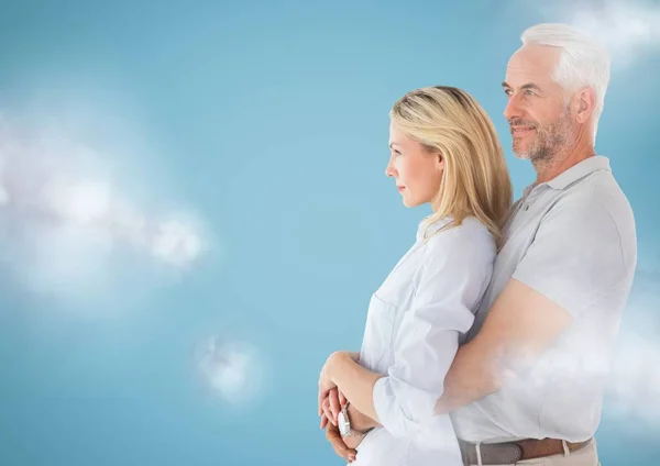 Couple regardant à gauche sur fond bleu avec des nuages — Photo
