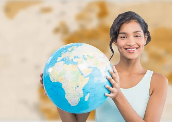 Woman with globe against brown blurry map — Stock Photo, Image
