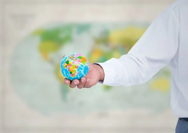 Arm med globe mot suddig karta — Stockfoto