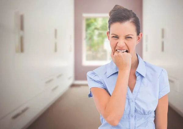 Стрессовая женщина кусает руку в комнате — стоковое фото