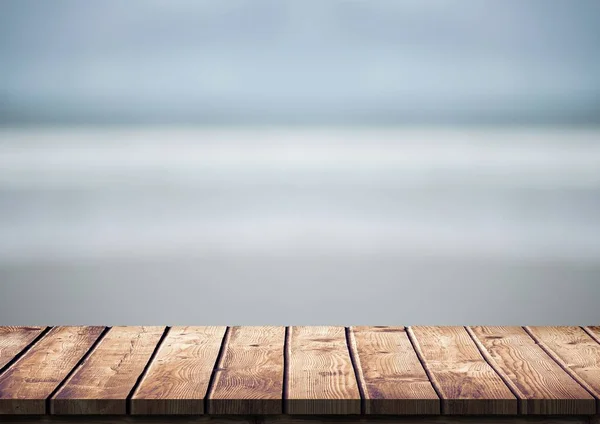 Tavolo in legno contro spiaggia sfocata — Foto Stock