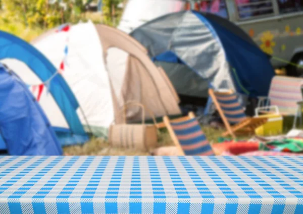 Picnic table against blurry campsite — Stock Photo, Image