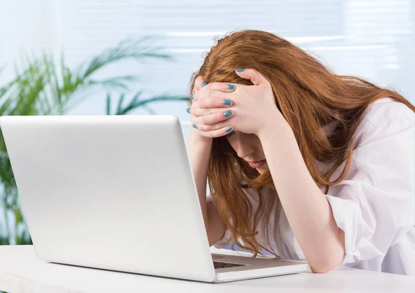 Mulher estressada na mesa do laptop no escritório — Fotografia de Stock