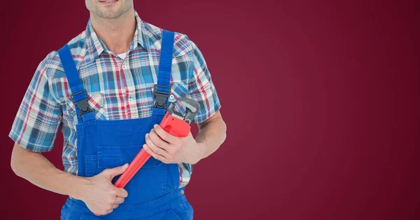 Mecánico con llave roja contra fondo granate —  Fotos de Stock