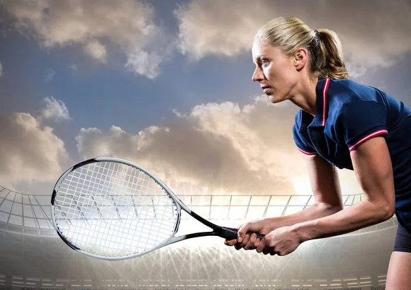 Tennis player with racket outstretched against stadium and sky with clouds — Stock Photo, Image