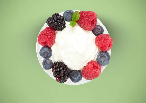 Bayas fruta con crema en plato sobre fondo verde —  Fotos de Stock