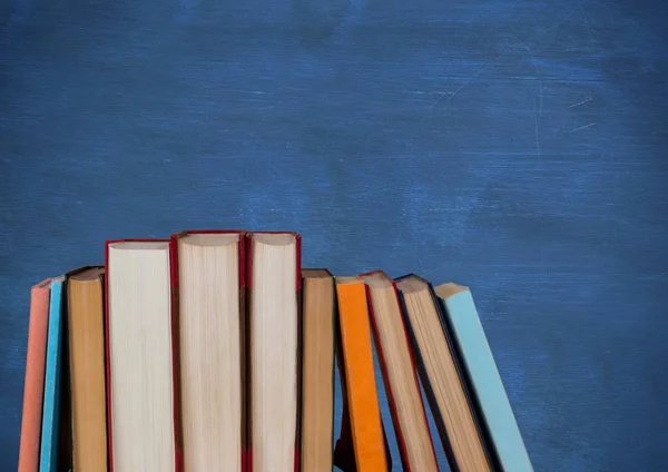 Stehende Bücher gegen blaue Tafel — Stockfoto