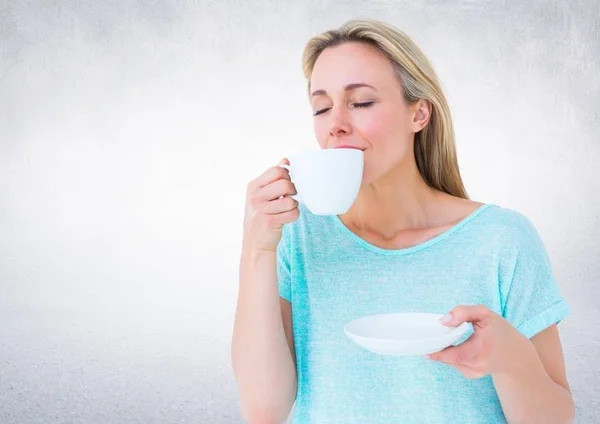 Beyaz duvar karşı beyaz fincan içme kadın — Stok fotoğraf