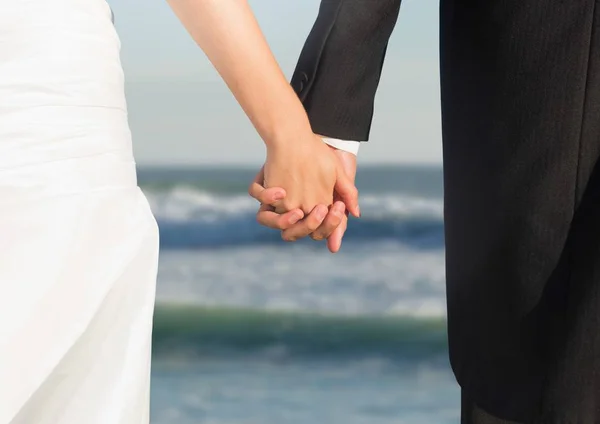 Svatební pár, drželi se za ruce po moři — Stock fotografie