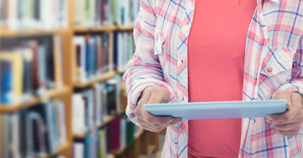 Kvinnans händer som håller tablett i biblioteket — Stockfoto