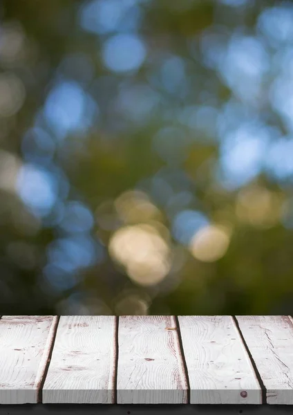 Table en bois blanc contre les feuilles floues — Photo