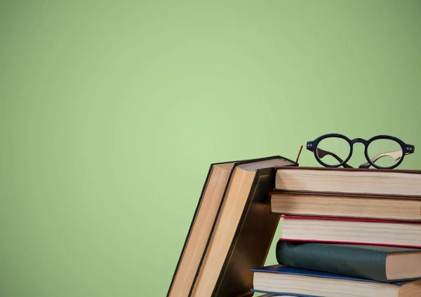 Pile of books and glasses against green background — Stock Photo, Image