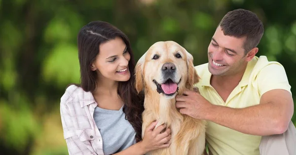 Casal com cão contra fundo verde embaçado — Fotografia de Stock