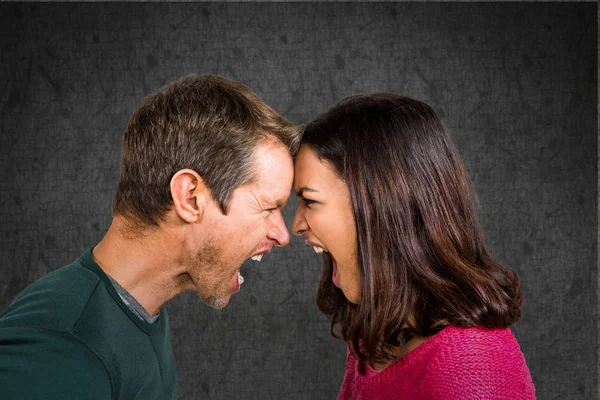 Couple en colère criant à chaque plus contre le mur de grunge — Photo