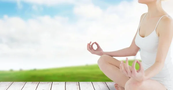 Vrouw Meditating door groene velden en sky — Stockfoto