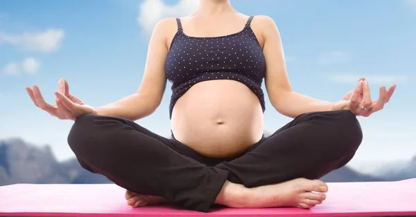 Mujer embarazada Meditando contra la montaña — Foto de Stock