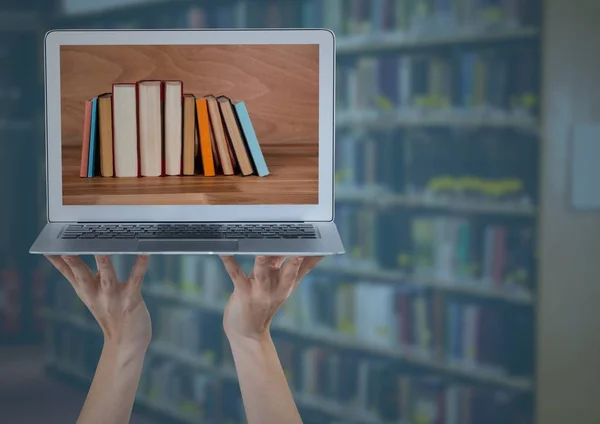 Manos con portátil que muestra espinas de libro contra estante borroso con superposición azul —  Fotos de Stock