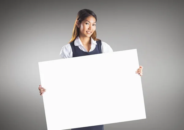 Empresaria con gran tarjeta en blanco sobre fondo gris — Foto de Stock