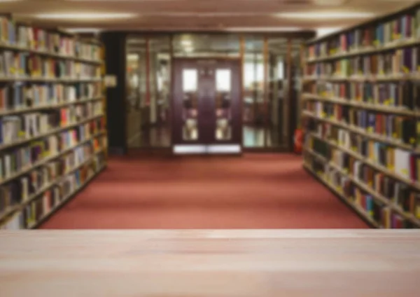 Wood table against blurry library — Stock Photo, Image