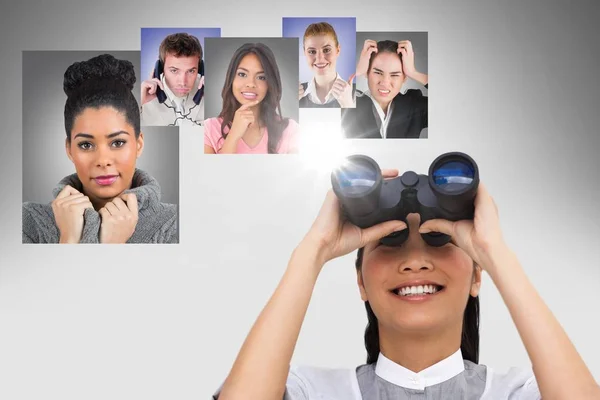 Smiling woman looking at flying portraits of business people with binocular — Stock Photo, Image