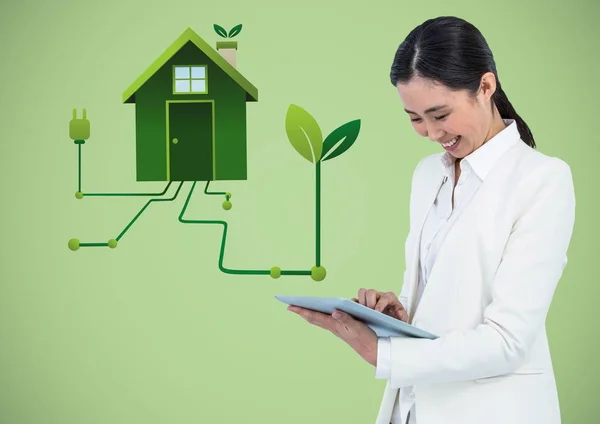 Женщина с планшетом и зеленый дом графики на зеленом фоне — стоковое фото