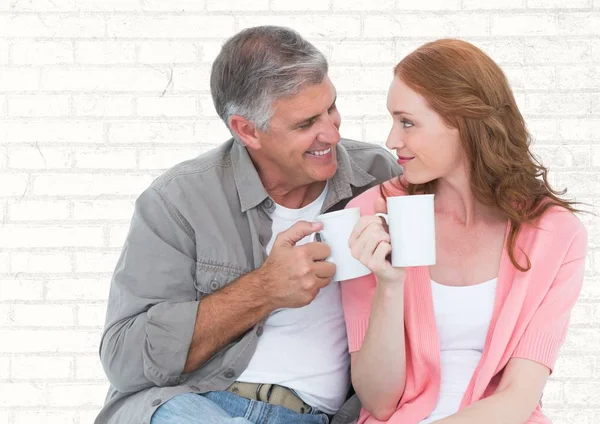 Hombre y mujer con tazas blancas contra pared de ladrillo blanco —  Fotos de Stock