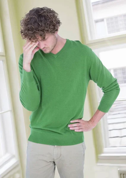 Estressado preocupado homem em verde jumper por janelas — Fotografia de Stock