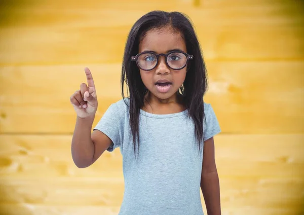 Menina em óculos contra painel de madeira amarela — Fotografia de Stock