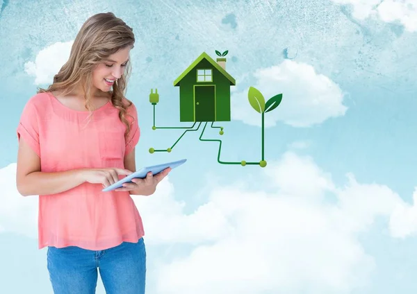 Kobieta z tabletu i zielony dom graficzny przeciwko niebo — Zdjęcie stockowe