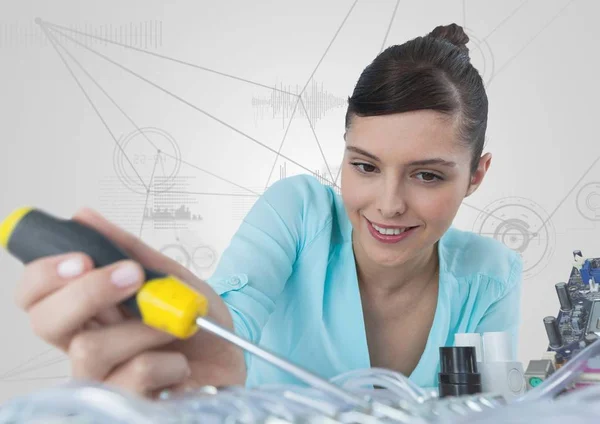 Kvinna med elektronik och skruvmejsel mot vit bakgrund med grafer — Stockfoto