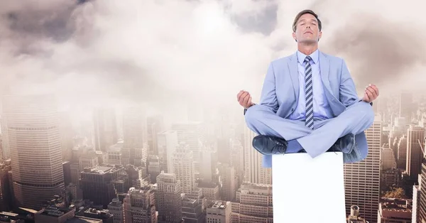 Businessman Meditating on plinth over city — Stock Photo, Image