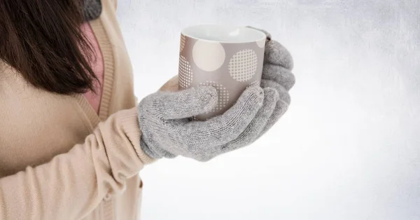 Primer plano de la mujer sosteniendo taza de lunares contra la pared blanca —  Fotos de Stock