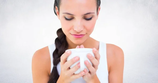 Close up of woman with white mug against white wall — Stock Photo, Image