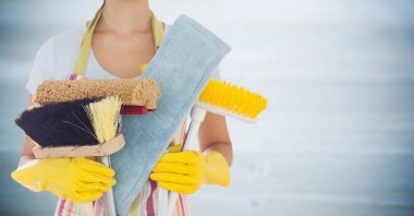 Woman in apron with brushes against blurry grey wood panel clipart