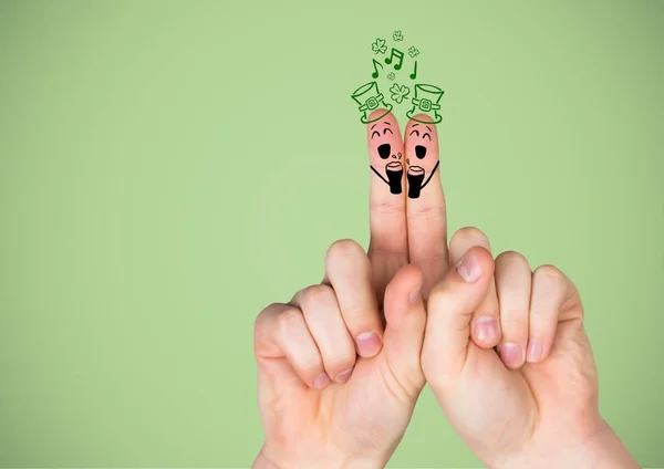 Manos con las caras del día de Patrick dibujadas sobre fondo verde — Foto de Stock