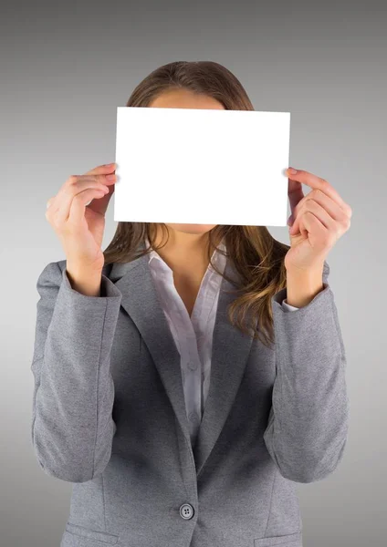 Obchodní žena s prázdnou kartou nad obličej proti šedé pozadí — Stock fotografie