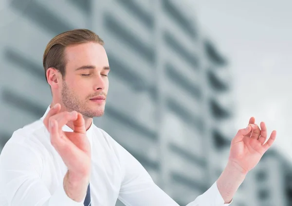 Businessman Meditating by office buildings — Stock Photo, Image