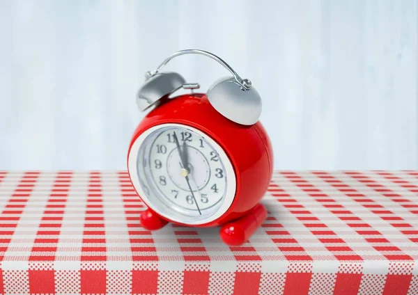 Klocka på röd bordsduk — Stockfoto