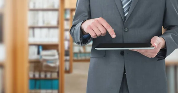 Man vidrör tablett i biblioteket — Stockfoto