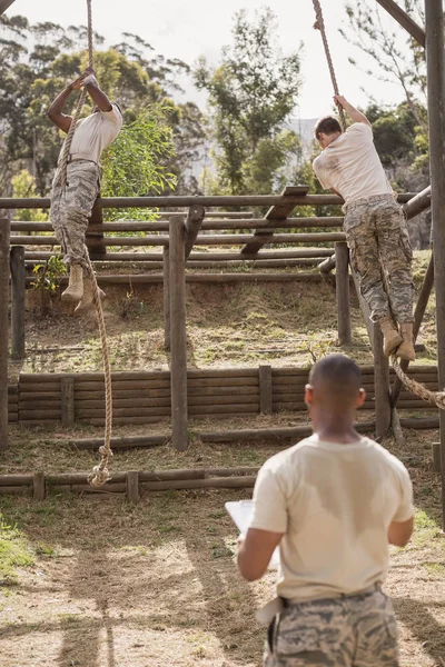 Soldados militares escalando corda — Fotografia de Stock