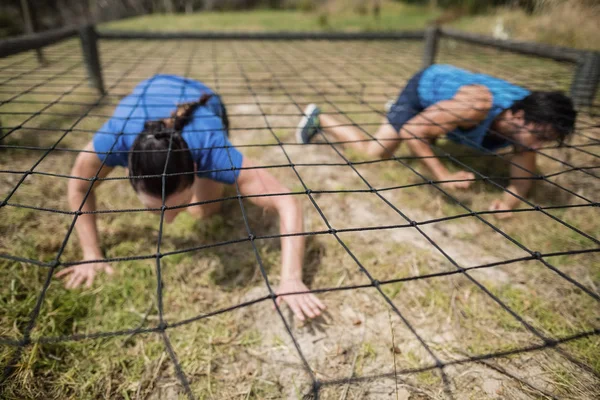 Apto homem e mulher rastejando sob a rede — Fotografia de Stock