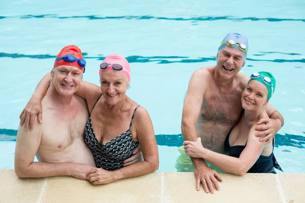 Casais seniores desfrutando na piscina — Fotografia de Stock